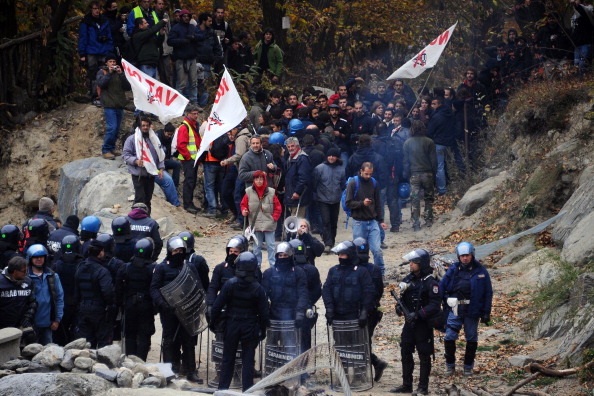 Demonstrators of the "No Tav" (No to High-Speed Trains) movement are stopped by police forces on October 23th, 2011, in Chiomonte, during a protest against a high-speed train line between Lyon and Turin, near the village of Baita Clarea in the Alpine region of Val di Susa on October 23, 2011. The protest organised by the No Tav (No to High-Speed Trains) movement and residents of the Susa Valley have fiercely opposed the plan, saying the construction of tunnels would damage the environment. France and Italy signed a deal in 2001 on building a line through the area, a strategic link in the European network that would cut travel time between Milan and Paris from seven to four hours. AFP PHOTO/ OLIVIER MORIN (Photo credit should read OLIVIER MORIN/AFP/Getty Images)