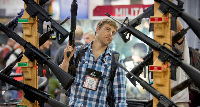 Michael Kiefer, of DeFuniak Springs, Fla., checks out a display of rifles at the Rock River Arms booth during the 35th annual SHOT Show, Thursday, Jan. 17, 2013, in Las Vegas. The world's largest gun and outdoor trade show runs through Friday. (AP Photo/Julie Jacobson)