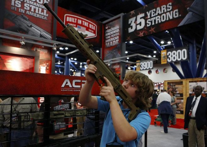 WCENTER 0XNFAEAJGD epa03686671 James Beaver, 13, looks through the scope of a Bushmaster gun during the 2013 National Rifle Association (NRA) Annual Meetings & Exhibits at the George R. Brown Convention Center in Houston, Texas, USA, 03 May 2013. The National Rifle Association is a nonprofit organization that promotes firearm ownership, as well as police training, firearm safety, marksmanship, hunting and self-defense training in the United States. The association has over four million members. EPA/AARON M. SPRECHER